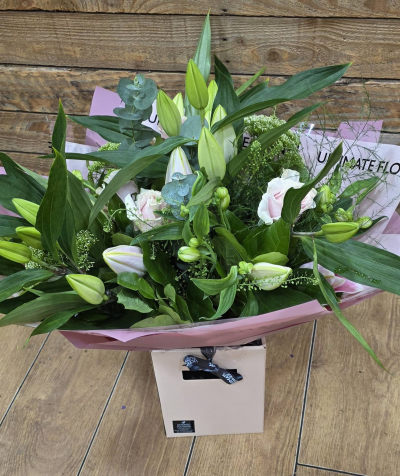 Lily Whisper - An elegant bouquet of soft pinks and fresh greens, featuring striking lily buds and delicate textural accents for a graceful finish.