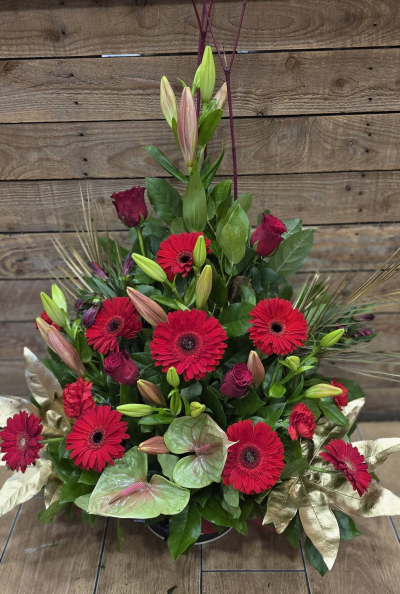 Red Opulence - A dramatic front-facing arrangement in rich red and crimson tones, beautifully styled with lush greenery and elegant golden accents.