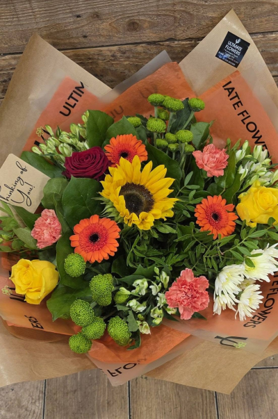Amber Glow - A vibrant bouquet bursting with sunny yellows, fiery oranges and fresh green tones for a bright, uplifting finish.