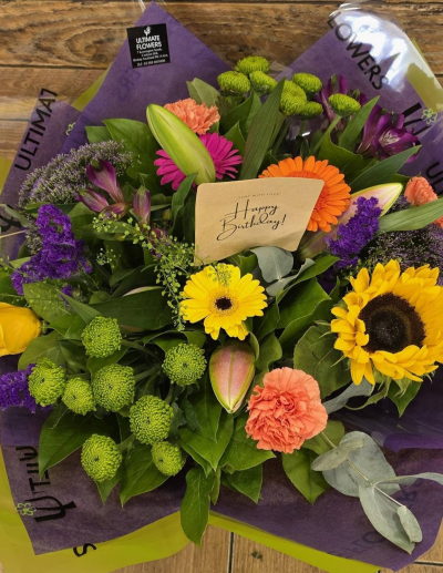 Sunshine Pop - A vibrant bouquet bursting with bold yellows, oranges, pinks and purples, balanced with fresh green tones for a joyful splash of colour.