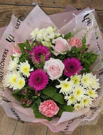 Pink Champagne - A cheerful bouquet combining soft pinks, vibrant berry tones and fresh whites, finished with lush greenery for a bright, pretty look.